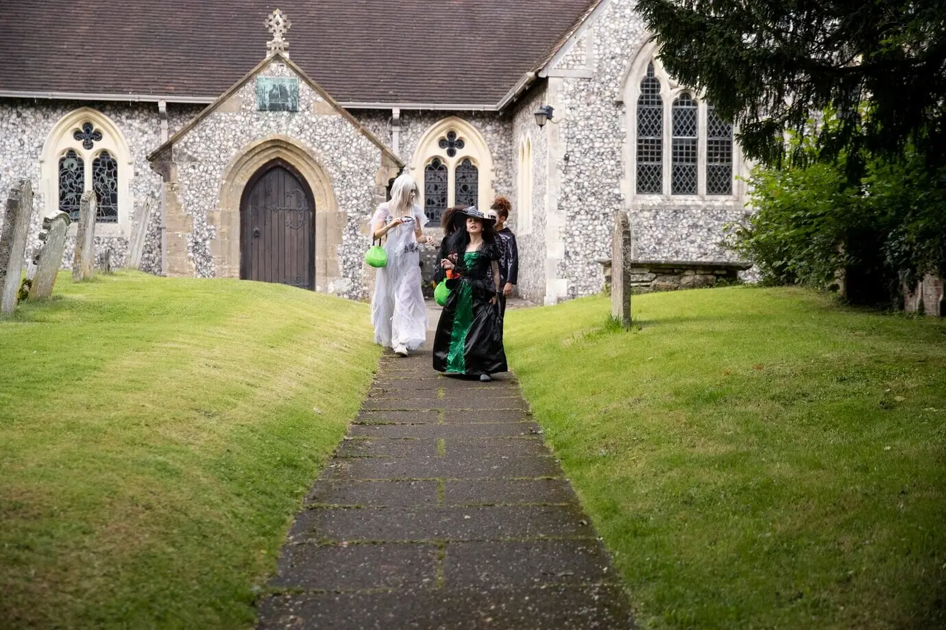 Kinder in Kostümen, die zum Süßes-oder-Saures-Gehen unterwegs sind.